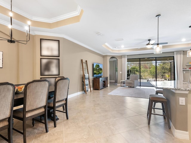 dining space with crown molding, ceiling fan, and a raised ceiling