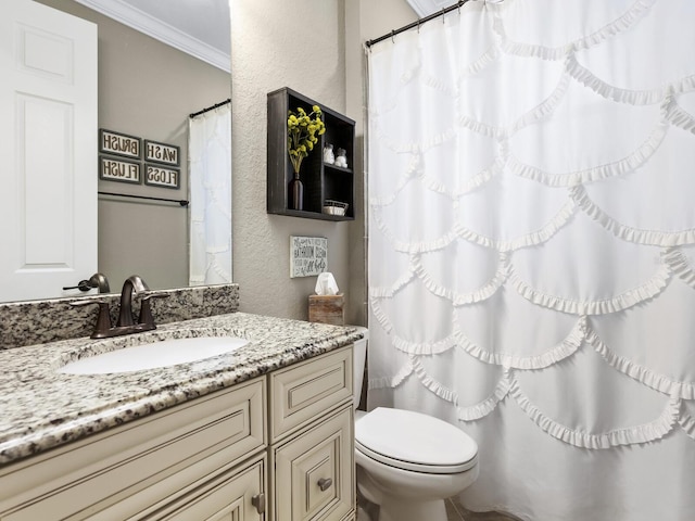 bathroom with crown molding, vanity, and toilet