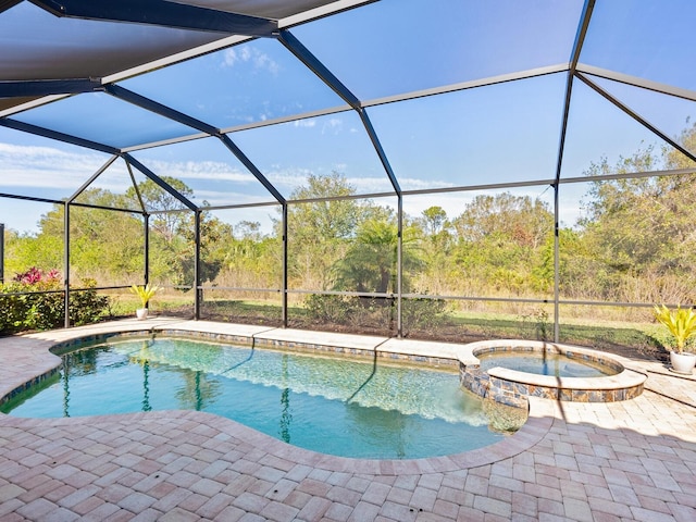 view of pool featuring an in ground hot tub, glass enclosure, and a patio