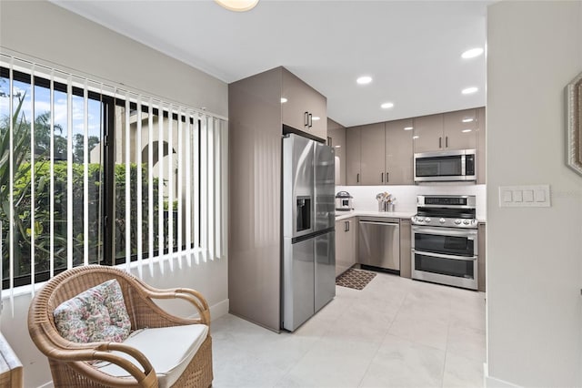 kitchen with stainless steel appliances, tasteful backsplash, gray cabinetry, and light tile patterned floors