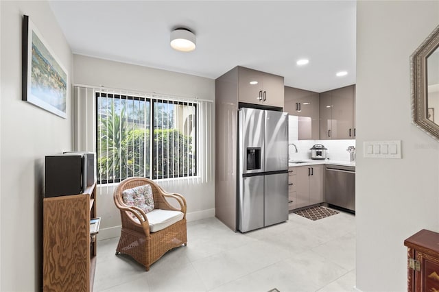 kitchen featuring appliances with stainless steel finishes, sink, gray cabinetry, and backsplash