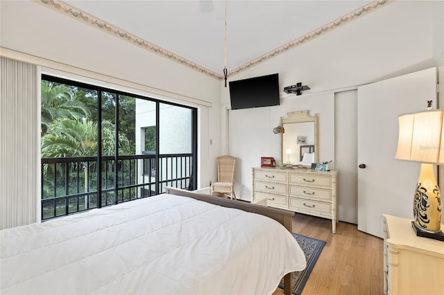 bedroom with vaulted ceiling, access to outside, and light hardwood / wood-style flooring