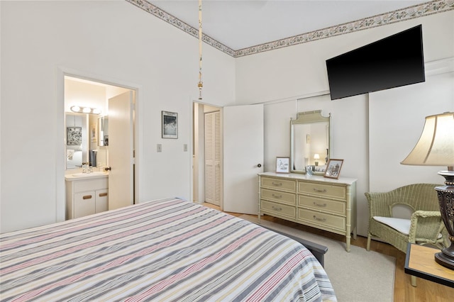 bedroom featuring sink, a closet, a high ceiling, and ensuite bathroom