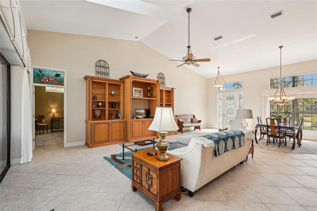 living room featuring light tile patterned floors, ceiling fan with notable chandelier, and high vaulted ceiling