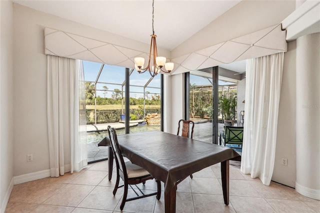 dining area featuring light tile patterned floors, a notable chandelier, a wealth of natural light, and vaulted ceiling