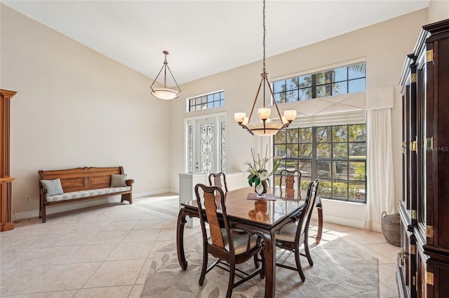 tiled dining area with a high ceiling and a notable chandelier