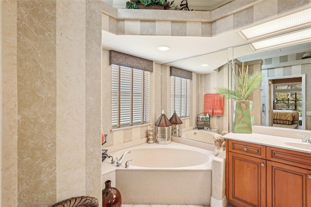 bathroom with vanity, a tub, and a skylight