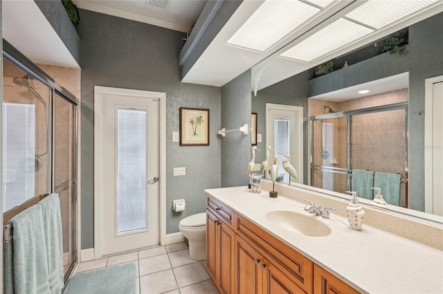 bathroom with vanity, a shower with door, tile patterned floors, and toilet