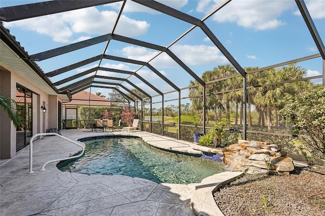 view of swimming pool with glass enclosure and a patio area