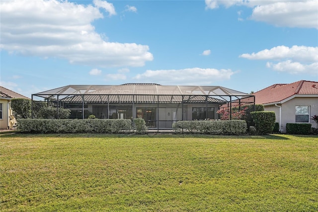 back of property featuring a yard and glass enclosure