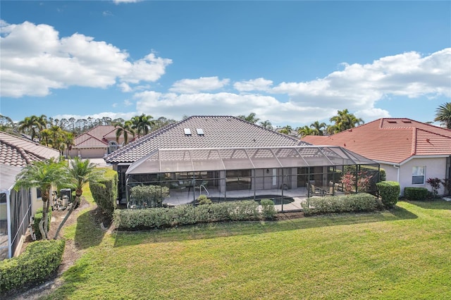 back of property with a yard, a patio area, and glass enclosure