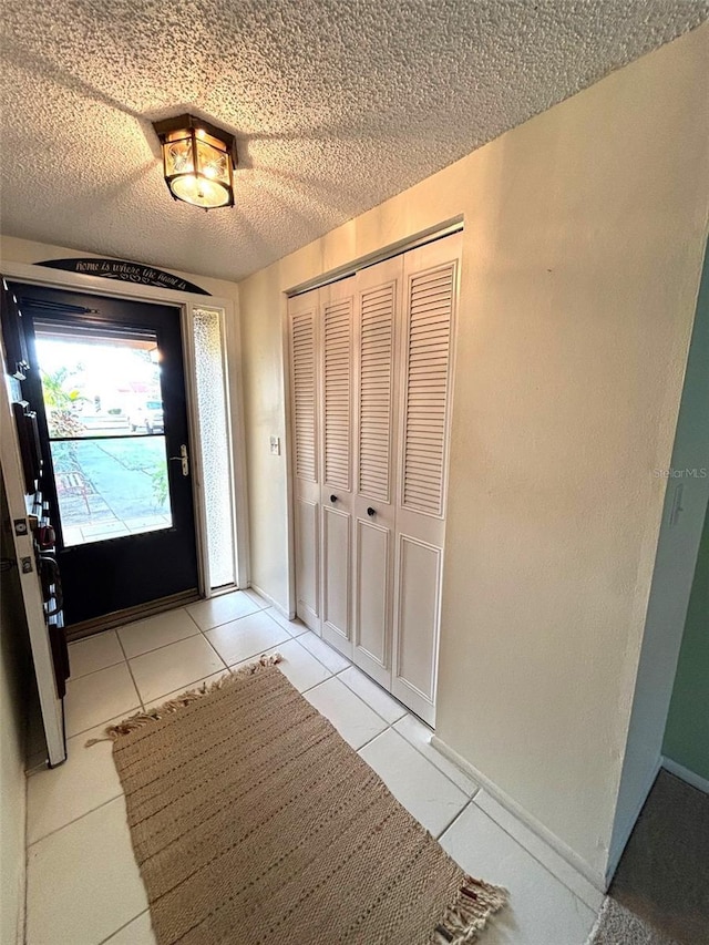 doorway with light tile patterned floors and a textured ceiling