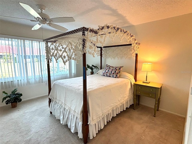 bedroom with ceiling fan, carpet floors, and a textured ceiling