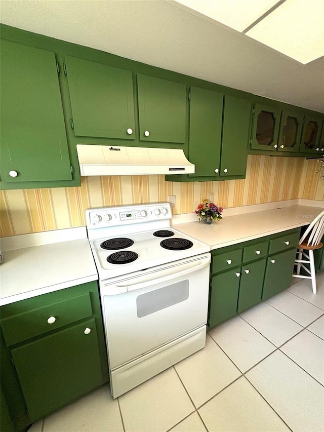 kitchen featuring light tile patterned floors, range hood, green cabinetry, and white range with electric cooktop