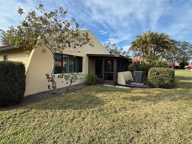 rear view of property featuring a sunroom and a yard