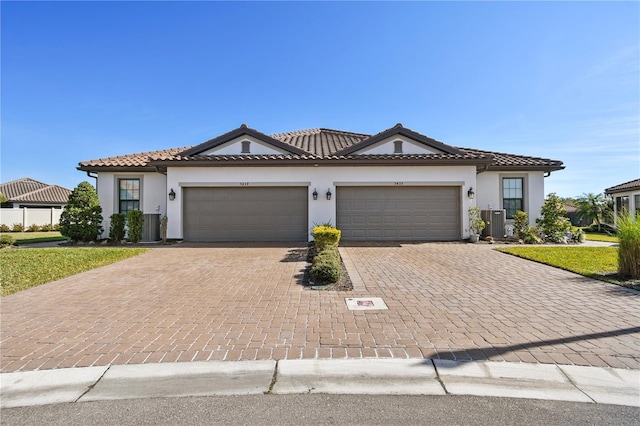 mediterranean / spanish-style house featuring a garage and cooling unit