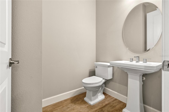 bathroom featuring wood-type flooring and toilet