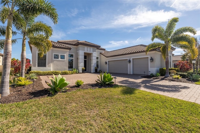 mediterranean / spanish-style house featuring a garage, a tiled roof, decorative driveway, a front lawn, and stucco siding