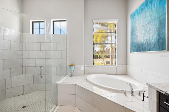 bathroom featuring a bath, a shower stall, and plenty of natural light