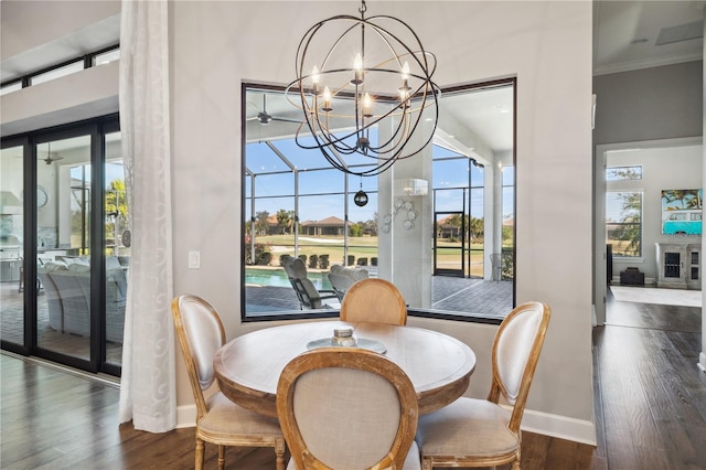 dining room featuring an inviting chandelier, dark wood-type flooring, baseboards, and ornamental molding