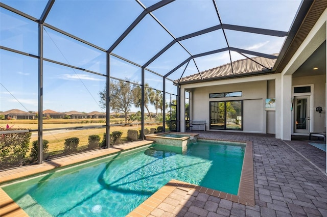 view of swimming pool with a patio area, a pool with connected hot tub, and a lanai
