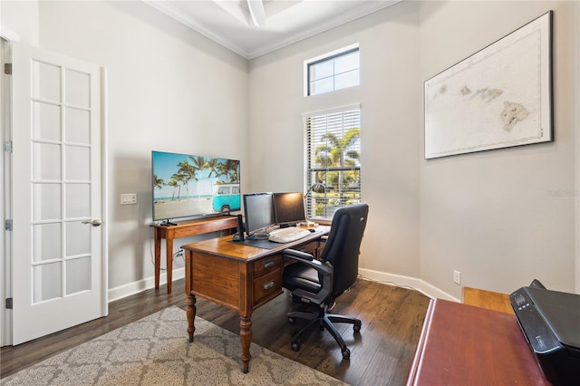 home office featuring a high ceiling, baseboards, ornamental molding, and wood finished floors