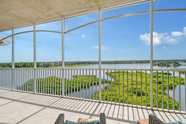 unfurnished sunroom featuring a water view and a healthy amount of sunlight