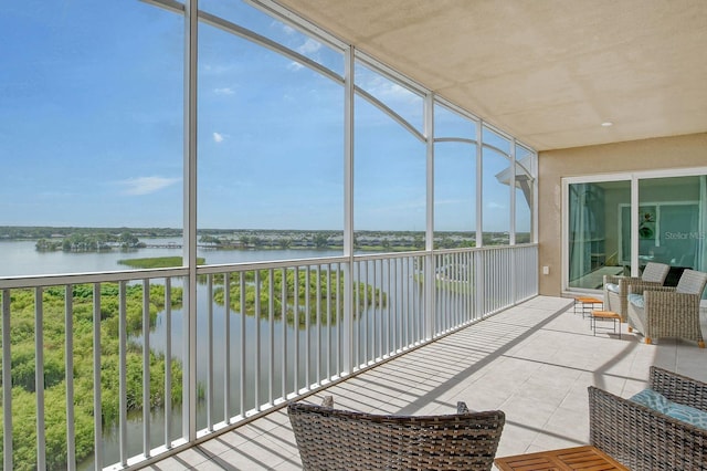 sunroom featuring a water view