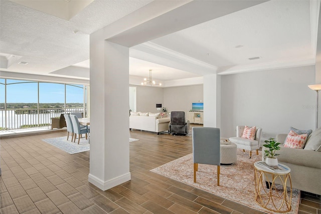 living area featuring baseboards, a water view, wood tiled floor, expansive windows, and a notable chandelier