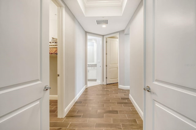 hallway featuring wood tiled floor, visible vents, and baseboards