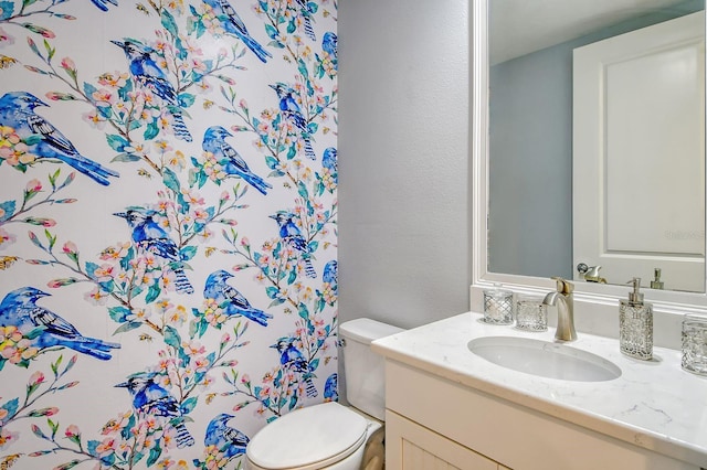 bathroom with toilet, a textured wall, a shower with curtain, and vanity