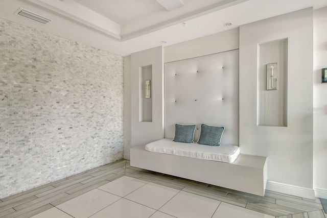 interior space featuring wood tiled floor, visible vents, and a raised ceiling