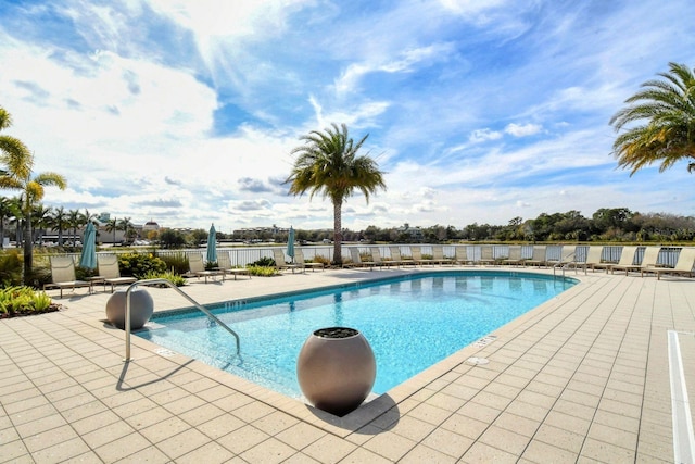 pool with a patio area and fence