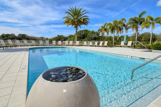 pool with a patio and fence