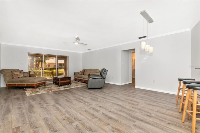 living room with hardwood / wood-style flooring, crown molding, and ceiling fan