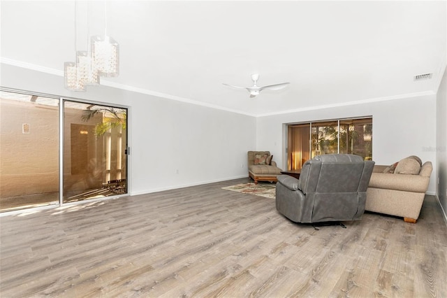 living room with ornamental molding, ceiling fan, and light hardwood / wood-style flooring