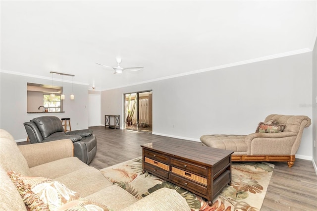 living room with ceiling fan, ornamental molding, and light hardwood / wood-style flooring