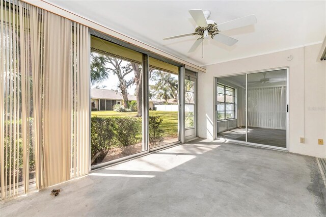 unfurnished sunroom featuring ceiling fan