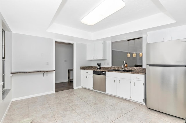 kitchen featuring white cabinetry, sink, a tray ceiling, and stainless steel appliances