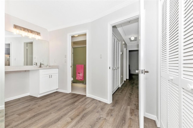 bathroom with hardwood / wood-style flooring, crown molding, and vanity