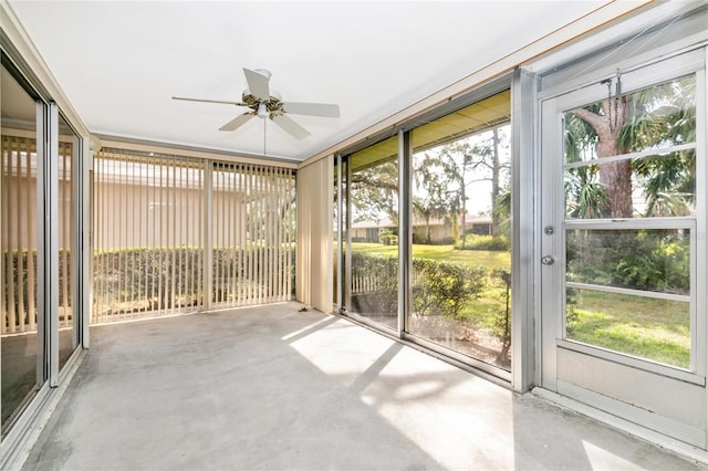 unfurnished sunroom featuring ceiling fan