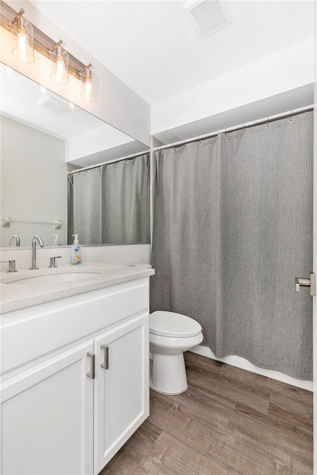 bathroom with vanity, hardwood / wood-style floors, and toilet