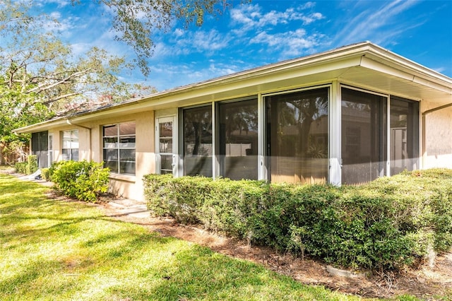 exterior space featuring a yard and a sunroom