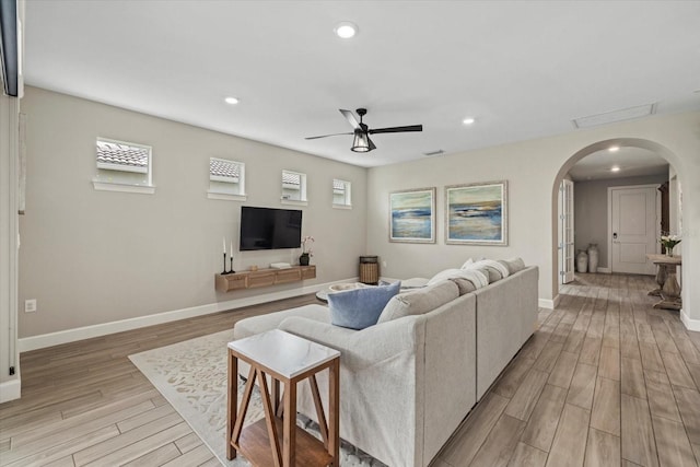 living room with ceiling fan and light hardwood / wood-style flooring