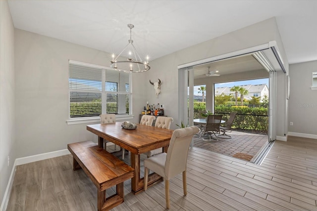 dining area with a wealth of natural light, a notable chandelier, and light hardwood / wood-style floors