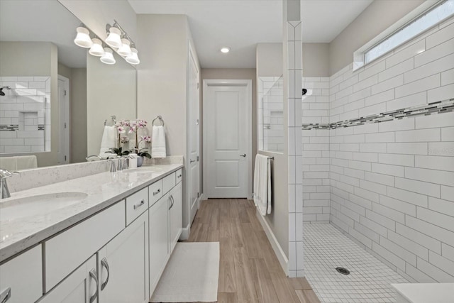 bathroom featuring vanity, hardwood / wood-style flooring, and tiled shower