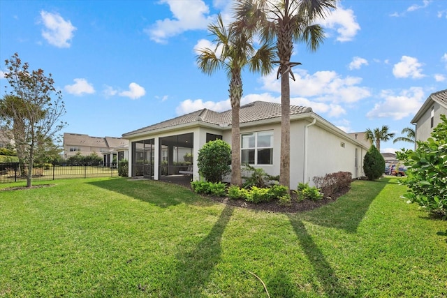 rear view of property featuring a sunroom and a yard