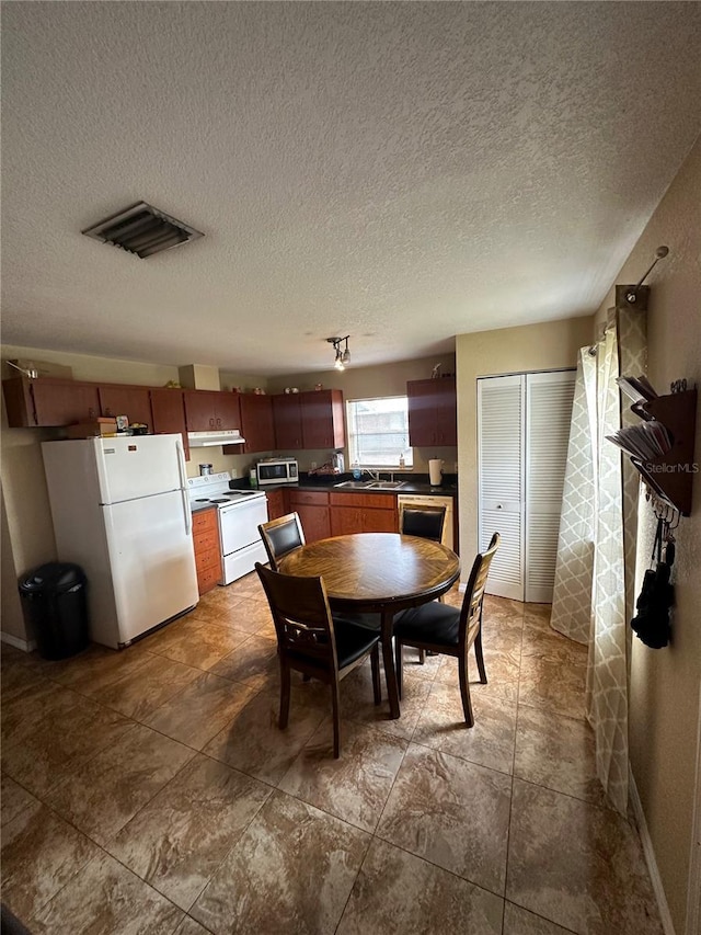 dining space with sink and a textured ceiling