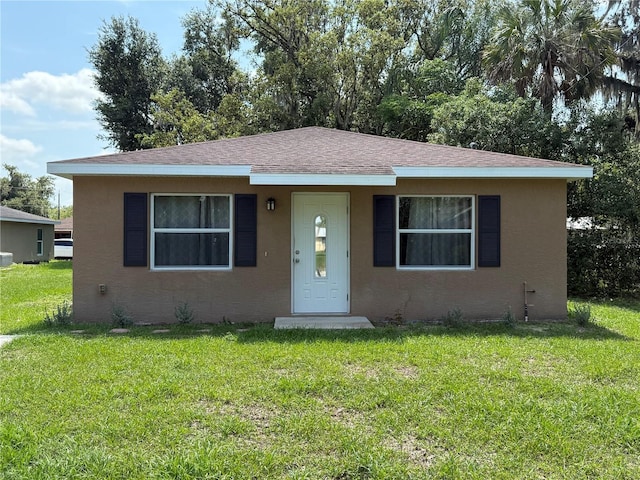 910 N Lee Ave, Arcadia, FL 34266 - bungalow with a front lawn, stucco siding, and a shingled roof