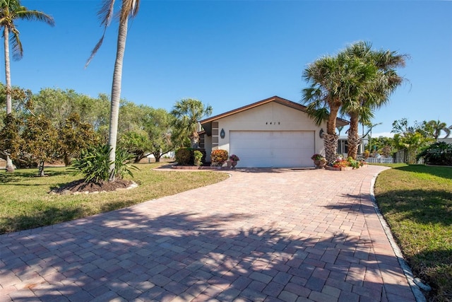 view of front of home with a front lawn, decorative driveway, and a garage